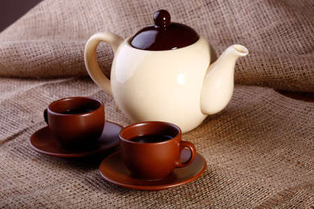 Pot of Coffee and cups standing on burlap backgroundの写真素材