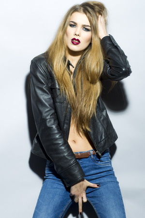 Beautiful woman in black leather jacket and jeansの写真素材