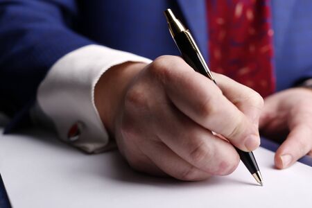 MCaucasian male hand in a business suit holding the pen and signing a documentale hand holding the penの写真素材