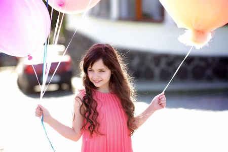 Pretty little girl holding balloons, horizontal photoの写真素材