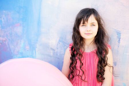 Pretty little girl on bright background looking forward, copyspace horizontal photoの写真素材