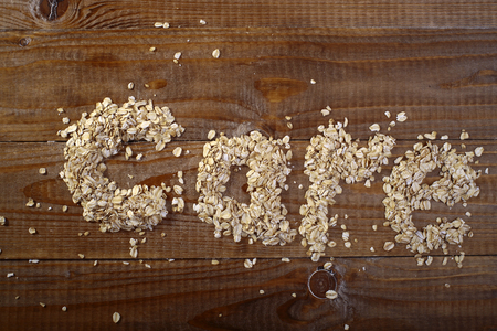 Oatmeal care word text on wooden table top, horizontal photoの写真素材