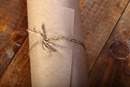Rolled paper on wooden table top closeup copyspace, horizontal pictureの写真素材