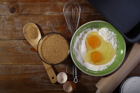 Ingredients and appliances for cooking on wooden table top with yolk in flour copyspace, horizontal pictureの写真素材