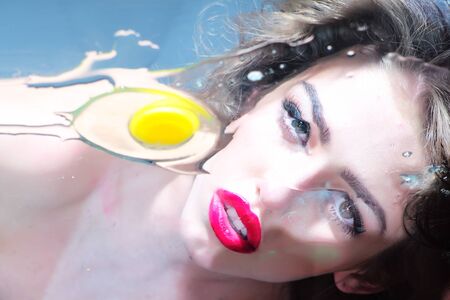 Adorable pretty cute girl with curly hair big beautiful eyes and bright pink lips looking through...
