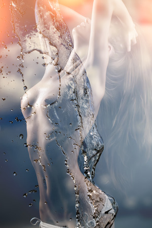 One naked young sexy girl with beautiful teats nipples belly and straight body standing with raised hands touching hair on black background with water and sky with cumulus texture, vertical pictureの写真素材
