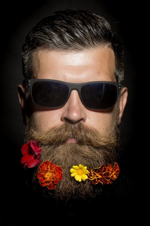 Head of gloomy unshaven man in sunglasses with long beard and hendlebar flowerbed moustache with...