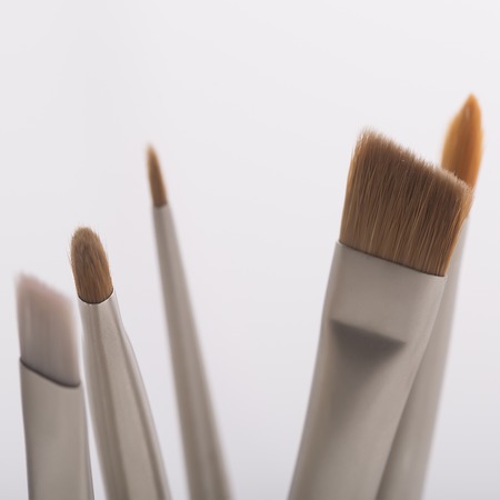 Set of many different professional soft make-up small brushes for eyeshadow for visagistes grey and brown colors on white background, square pictureの写真素材
