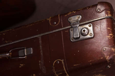 Closeup of old fashioned aged brown leather brief case standing indoor in studio, horizontal pictureの写真素材