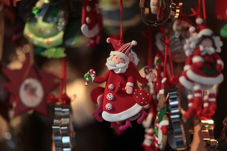 Santa Claus red tree toy is hanging under ceiling with other different colorful decorations creating Christmas moodの写真素材