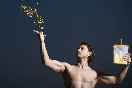 One young unshaven muscular strong man with curly hair bare chest holding plastic box with throwing...
