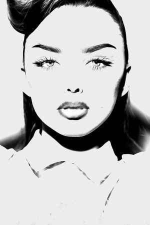 Portrait of young beautiful woman with soft lips in formal shirt with hair looking forward standing on studio background black and white, vertical pictureの写真素材