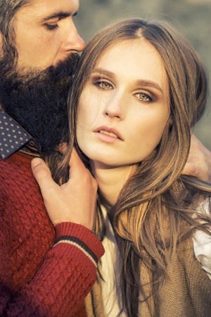 One beautiful stylish tender couple of young woman and senior man with long black beard embracing close to each other outdoor in spring sunny day, vertical pictureの写真素材