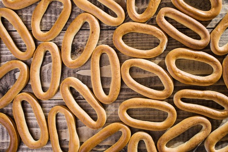 Photo top view seamless mass plenty of delicious hard oval cracknels poured out and laying on table made of wood on timber background, horizontal pictureの写真素材