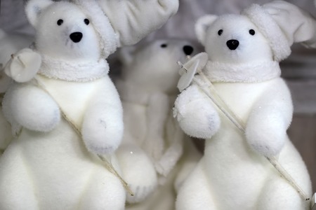 Closeup view of many little cute fluffy white tiy figures of white bears in hat and scarfs holding ski poles, horizontal pictureの写真素材