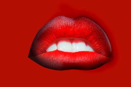 Closeup view of sexual beautiful female open red smiling lips with white teeth isolated on studio bright background, horizontal pictureの写真素材