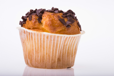 Delicious sweet dessert cupcake in paper basket with chocolate chips fattening food tasty baked refreshment isolated on white background closeup, horizontal pictureの写真素材