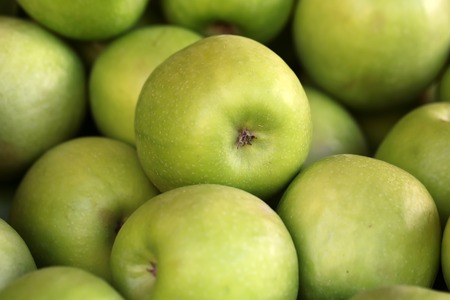 Photo closeup many clean organic fresh tasty ripe green apples crop fruit full of vitamin for healthy eating diet ball form for sale on natural background, horizontal pictureの写真素材