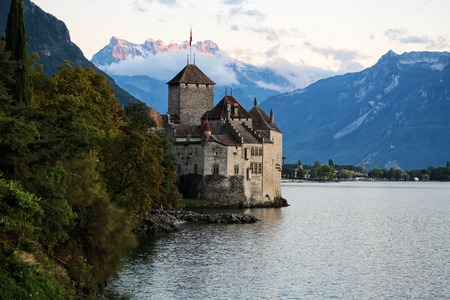 MONTREUX, SWITZERLAND - September 18, 2015: Pecturesque view of ancient Chillon castle on shores of Lake Geneva in canton of Vaud on Alps mountains covered with clouds background, horizontal photoのeditorial素材