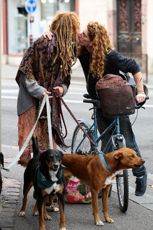 COLMAR, FRANCE - September 18, 2015:  Redheaded young woman with dogs and man on bicycle kiss on sidewalk in Colmar city, vertical photoのeditorial素材