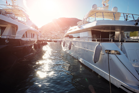 MONTE CARLO, MONACO - September 20, 2015: Luxury yachts in marina on coastline of Monte Carlo background at sunset, horizontal photoのeditorial素材
