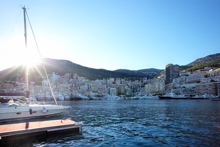 Panoramic view of yachts in port of Monte Carlo on urban waterfront background at sunset, horizontal photoの写真素材