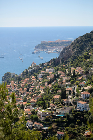 Monte Carlo, Monaco - September 20, 2015: view of densely populated city at bottom of mountain and sea port harbor yachts offshore day time blue sky on seascape background, vertical pictureのeditorial素材