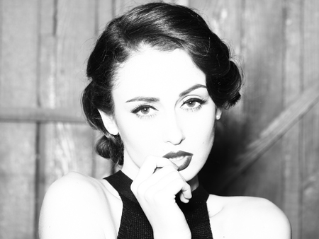 Portrait of beautiful sensual sexy fashionable retro elegant young adult woman with classic hairstyle and red lips indoor on wooden background, horizontal pictureの写真素材