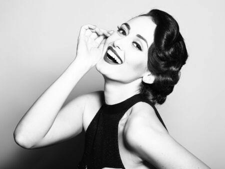 Portrait of attractive sensual glamour retro elegant young adult smiling woman with classic hairstyle and red lipsの写真素材