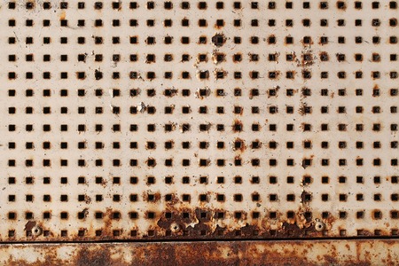 Plate metallic rusty with square holes slots perforated sheet shield screen on metal background