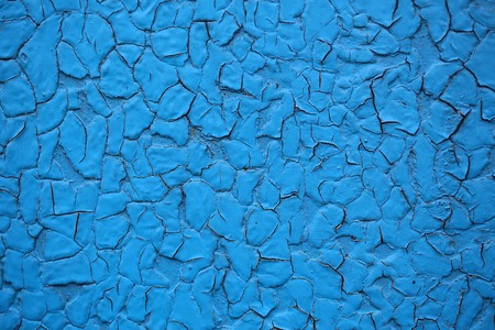 Cracked paint coat layer on iron sheet plate screen aged grungy rough surface with rusty spots damaged on blue backgroundの写真素材