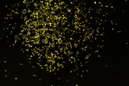 Golden glitter sparkle on black background with place for textの写真素材