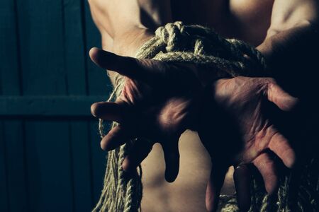 Young man with muscular body tied with ropeの写真素材