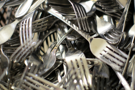 Antique silver utensils. Closeup of shiny silver fork bunch.