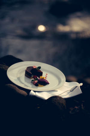 Picnic near water of decorated dessert served with spoon on napkinの写真素材