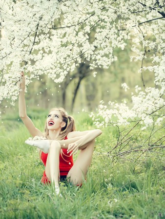 Beautiful happy young woman enjoying beauty in a flowering spring gardenの写真素材