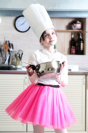 Baby girl in the cook hat with potの写真素材