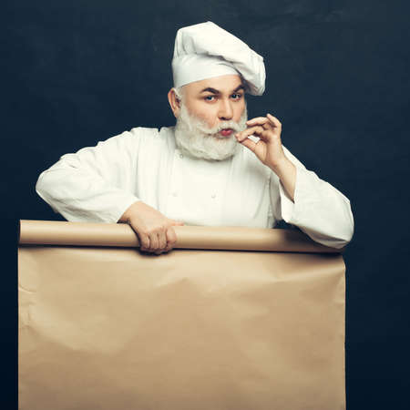 Cook holding parchment paper brown color on grey background, copy spaceの写真素材