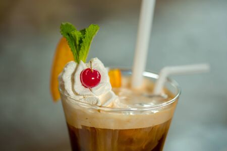 Coffee with cream and ice cream decorated with mint leaf cherry and orange slice