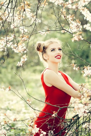 Beautiful happy young woman enjoying beauty in a flowering spring gardenの写真素材