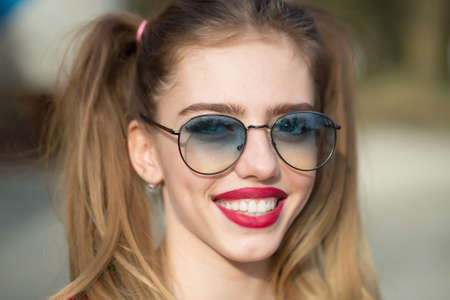 Fashion portrait of stylish pretty woman in sunglasses posing in outdoor, street fashionの写真素材