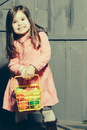 Girl with plastic vegetables and fruits, which are in basketの写真素材