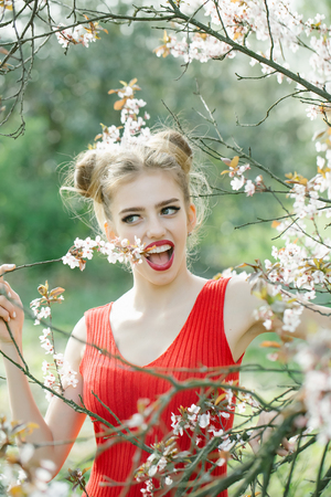 Beautiful sensual young woman enjoying beauty in a flowering spring gardenの写真素材
