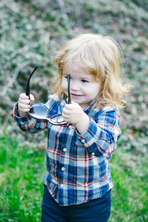 Carefree little baby boy in the park with green fresh grass in springの写真素材