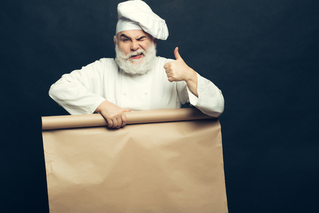 Cook holding parchment paper brown color on grey background, copy spaceの写真素材