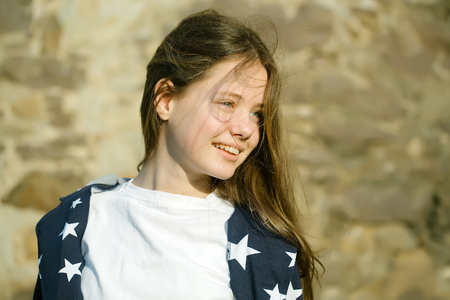 Beautiful young girl with long hair and smiling face sunny day outdoor closeupの写真素材