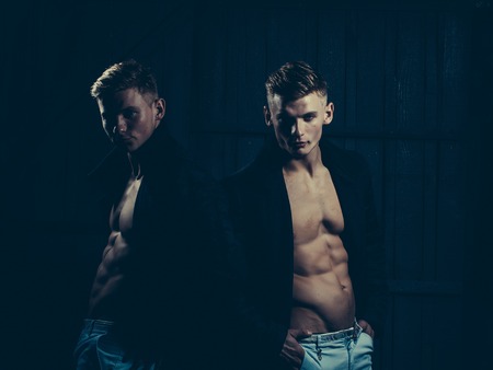 Two young men with sexy body showing their muscular torso and abs in open shirtsの写真素材