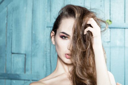 Young sensual model girl with pretty face pose in studio with long beautiful hair and bare shouldersの写真素材