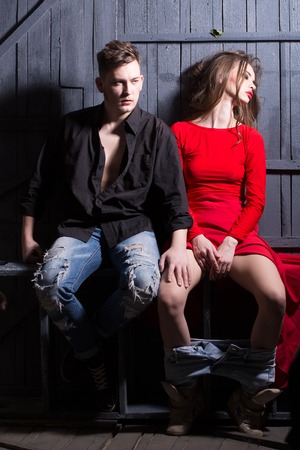 Sexy young couple of handsome boy with stylish hairdo and gorgeous girl in red dress posing togetherの写真素材
