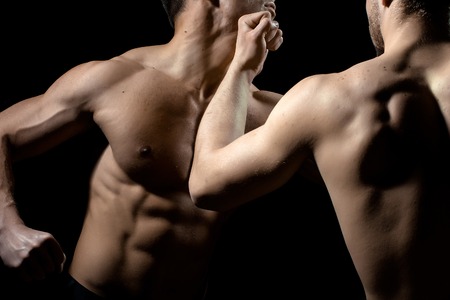 Young men boxing with sexy muscular body and bare torso in studioの写真素材